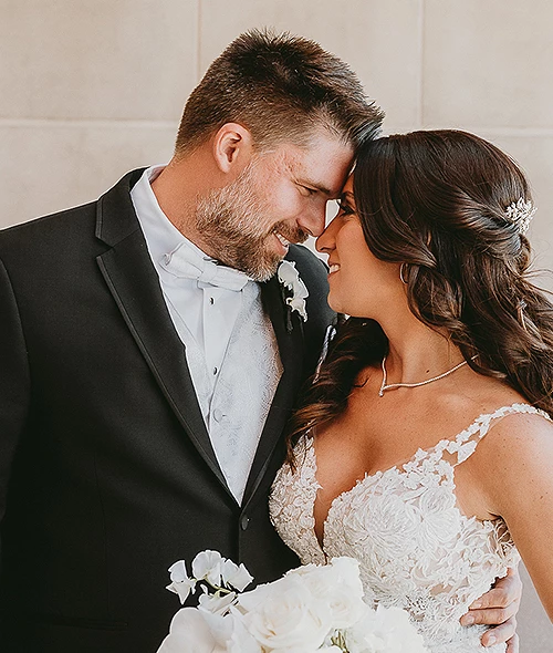 Bride and groom embrace and smile at Golf Resort & SPA The Westin Stonebriar PA, holding a white bouquet, looking happy and in love.