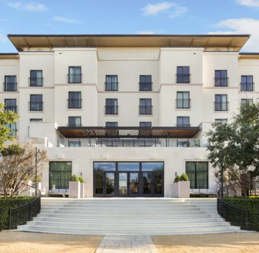 A modern four-story building with large windows, trees, and wide steps welcomes you to Golf Resort & SPA The Westin Stonebriar pa.