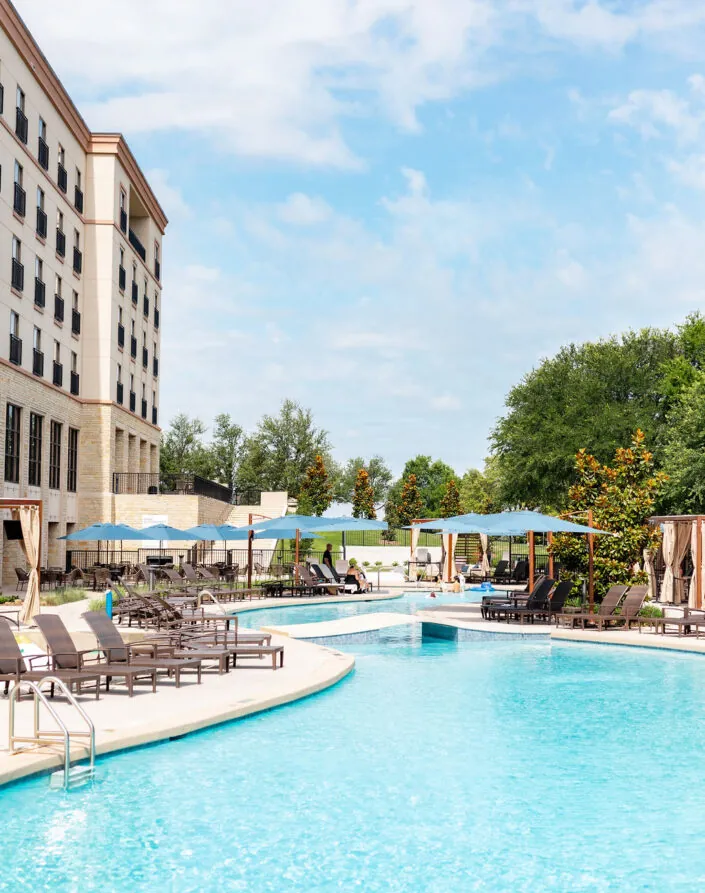 Large outdoor pool with lounge chairs and cabanas at Golf Resort & SPA The Westin Stonebriar PA, perfect for sunny days under blue skies.