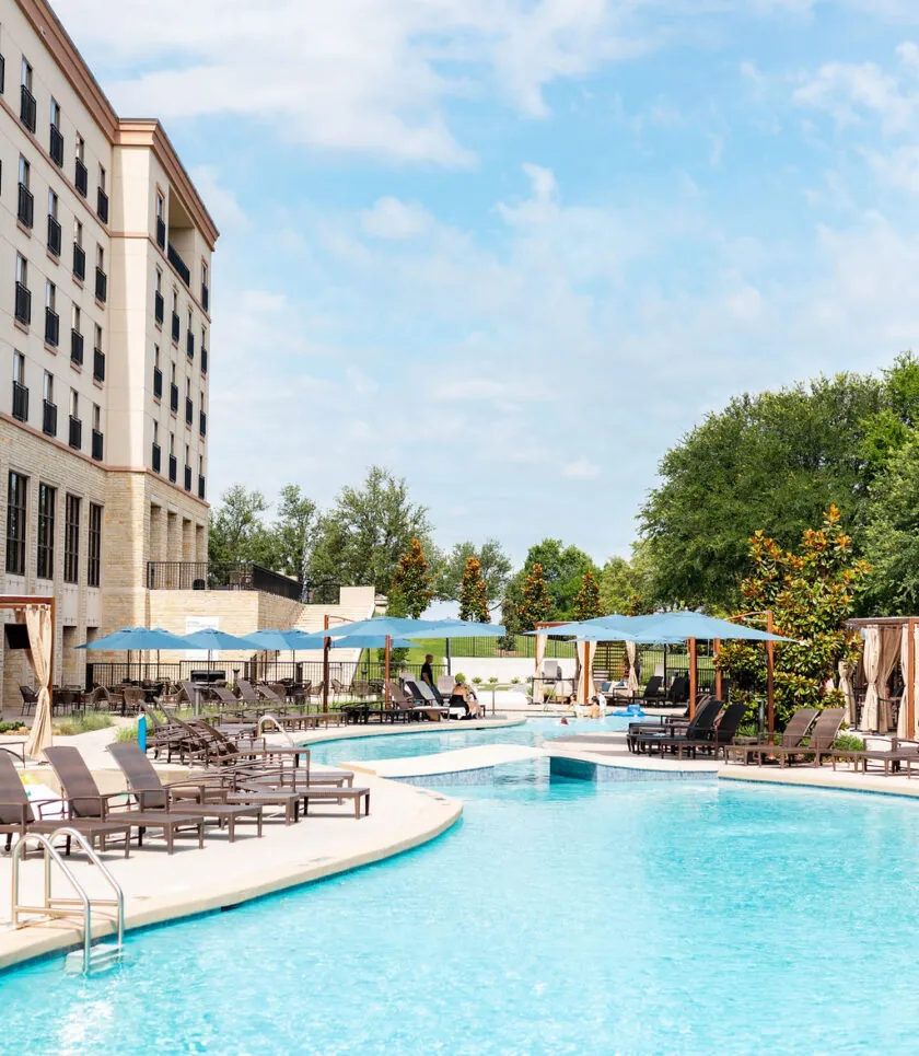 Large outdoor pool with lounge chairs and cabanas at Golf Resort & SPA The Westin Stonebriar PA, perfect for sunny days under blue skies.