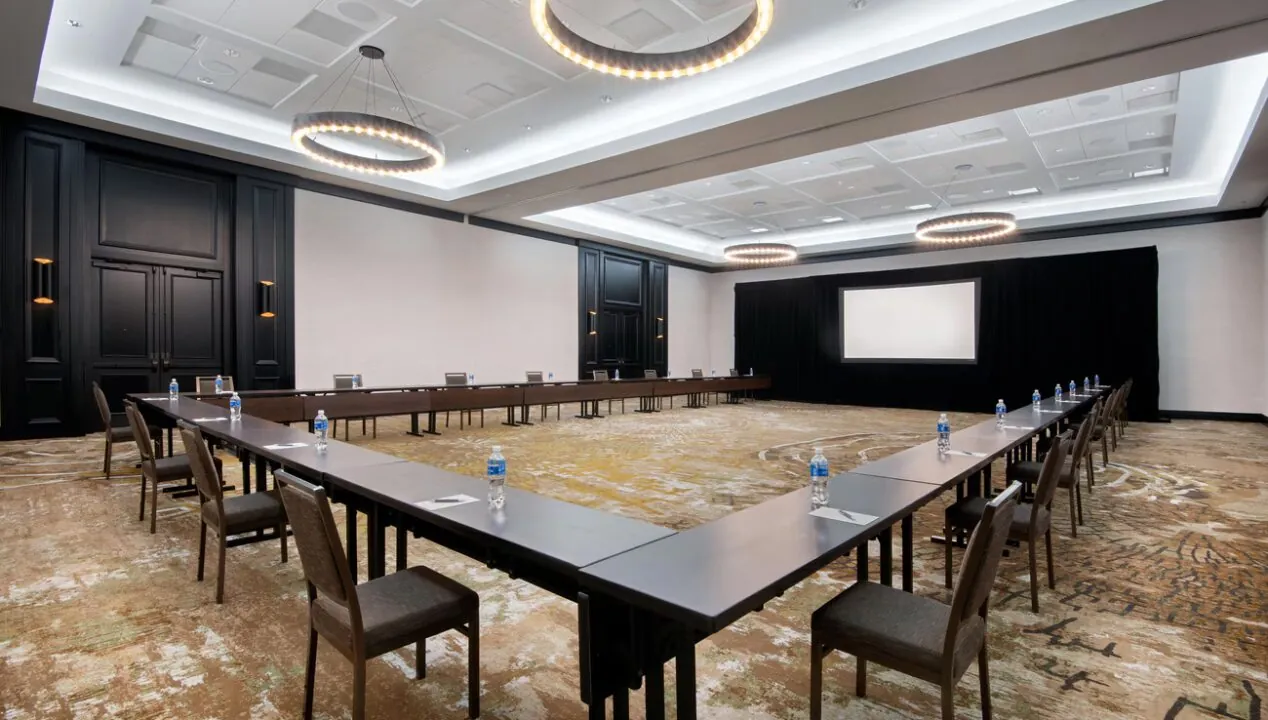 Spacious conference room at Golf Resort & SPA The Westin Stonebriar PA with U-shaped tables, bottled water, and circular ceiling lights.